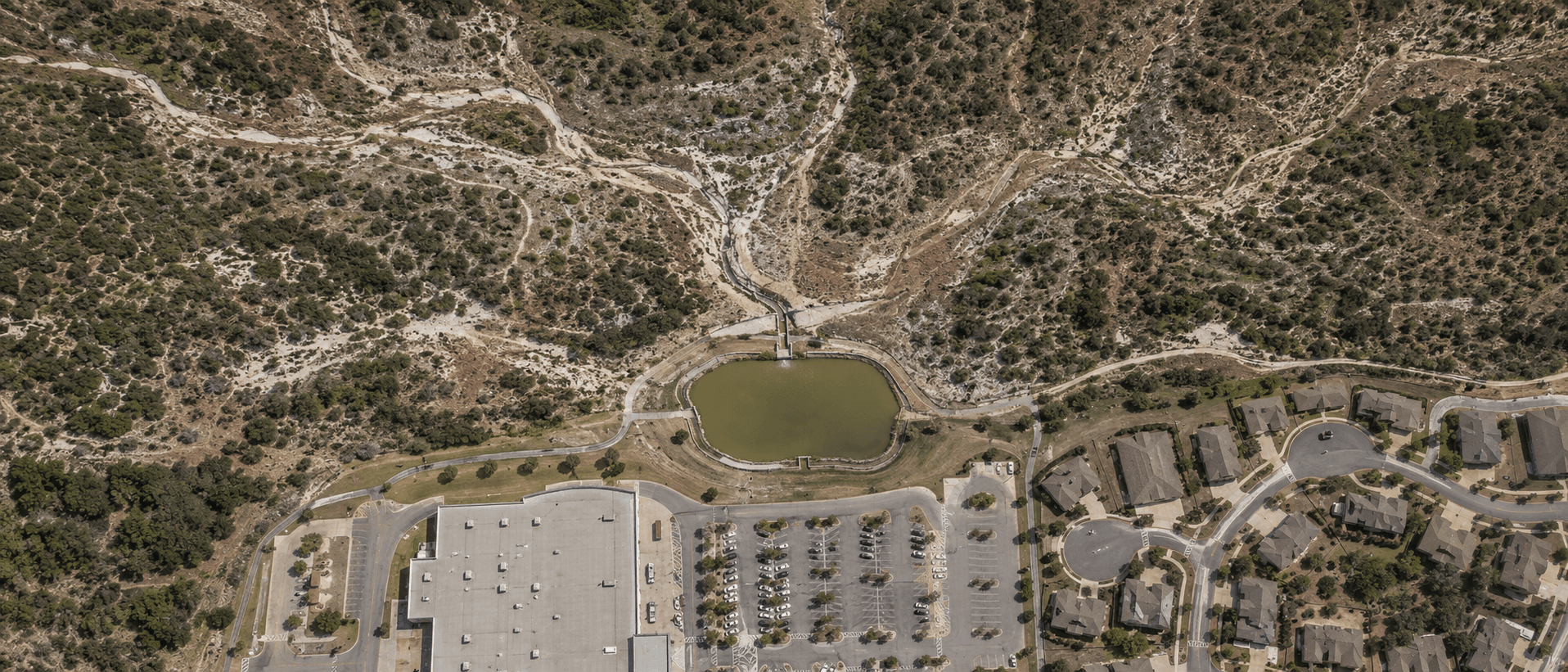 Aerial view of a Texas commercial detention pond and watershed
